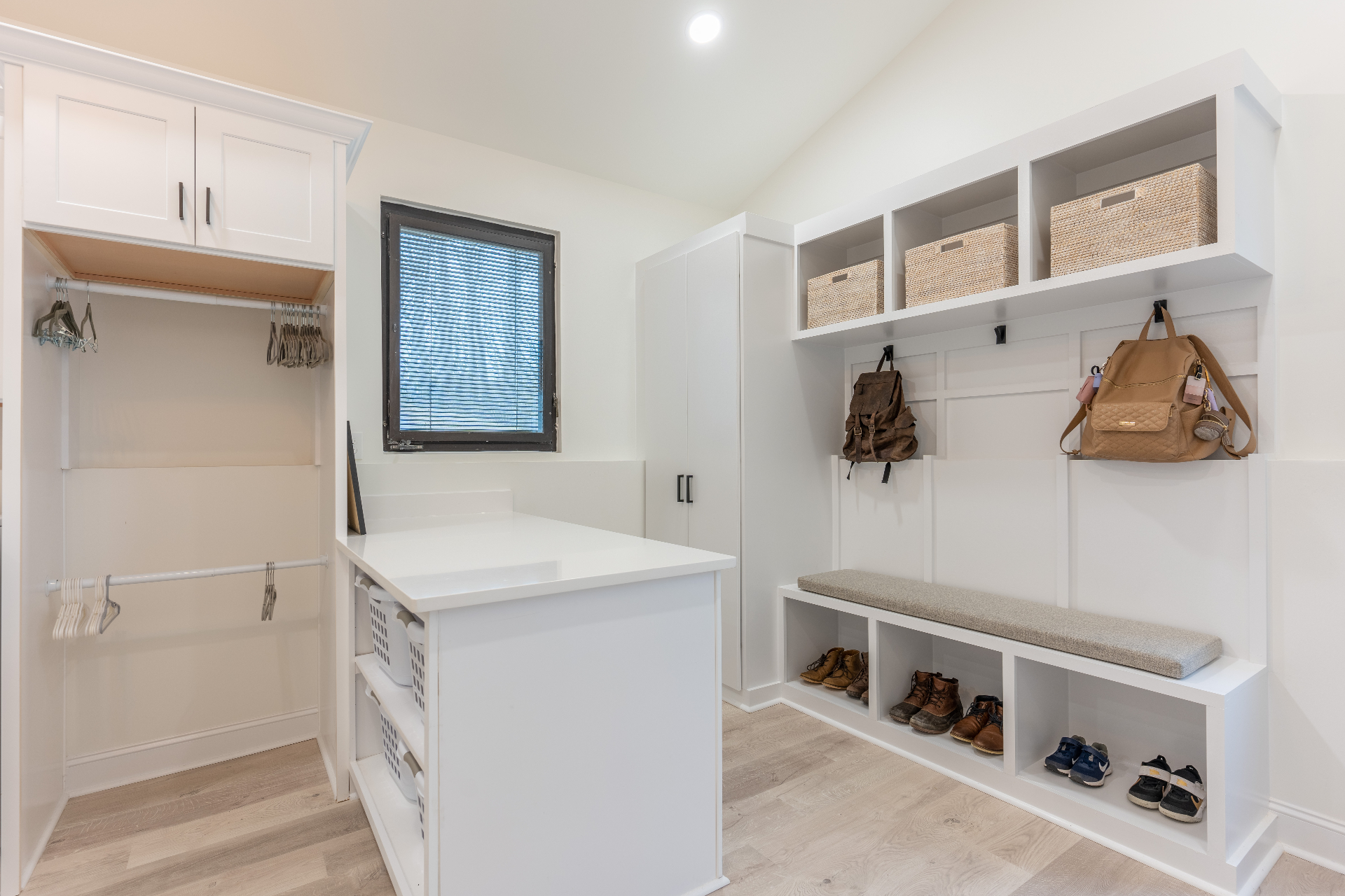Mudroom with island storage, built-in bench, and pantry cabinetry