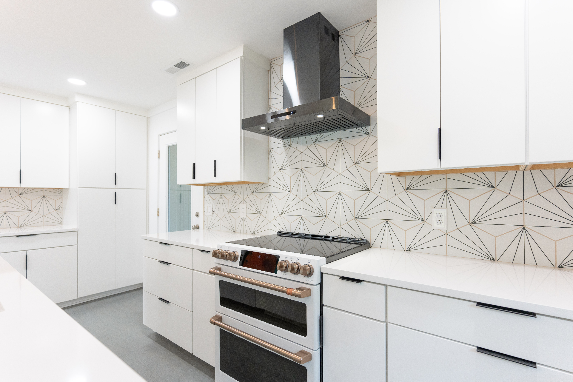 Double oven range with copper hardware and tile detail